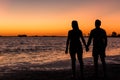 Young couple in love holding hands watching one of the best sunsets ever seen by the lake. Junin, Buenos Aires, Argentina Royalty Free Stock Photo