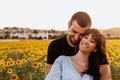 Young couple in love hugging each other in the sunflower field at sunset Royalty Free Stock Photo