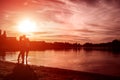 Young couple in love hugging and kissing on summer river bank at sunset. Man and woman having a date Royalty Free Stock Photo