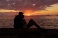 Young couple in love hugging watching the sunset by the sea on their relaxing vacation away from routine. Life style concept Royalty Free Stock Photo