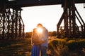 Young couple in love hugs on sunset amidst a bridge under construction. Man hugs woman closely. Outdoor portrait of couple Royalty Free Stock Photo