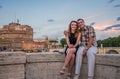 Young couple in love, husband and wife, on the stone bridge of the Tiber River embankment, against the backdrop of the Angel Vatic