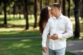 young couple in love is kissing in the park on a summer day. man and woman are hugging outdoors Royalty Free Stock Photo