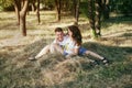A young couple in love is lying on the mown grass. A man and a woman have fun and indulge in hay throwing each other Royalty Free Stock Photo