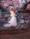 Young couple in love. A man and a woman are hugging on a huge tree. Themed creative wedding bright fantasy photography