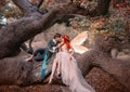 Young couple in love. A man and a woman are hugging on a huge tree. Themed creative wedding bright fantasy photography