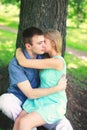 Young couple in love, man and woman resting near tree