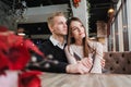 Young couple in love, man and woman on a romantic date in a cafe. Sit at a table by the window. On the table a bouquet Royalty Free Stock Photo