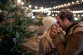 A young couple in love and moments of closeness on a snowy weather in the city. Christmas tree, love, relationship, Xmas, snow Royalty Free Stock Photo
