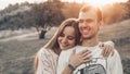 Young couple in love outdoor. They are smiling and looking at each other. evening sunlight, hugs and kisses, vintage style Royalty Free Stock Photo