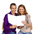 Young couple in love reading together a brochure Royalty Free Stock Photo