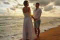 Young couple in love on a romantic date meets the sunset on the beach Royalty Free Stock Photo