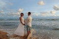 Young couple in love on a romantic date meets the sunset on the beach Royalty Free Stock Photo