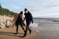 Young couple in love run away from waves. Happy lovers have fun on the beach Royalty Free Stock Photo