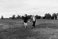 Young Couple in Love Running in a Big Open Outdoor Field in the Spring Holding Hands and Laughing Royalty Free Stock Photo