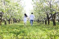 Young couple in love running in spring blossom garden