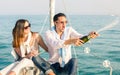 Young couple in love on sailing boat cheering with champagne wine bottle - Happy girlfriend birthday party cruise travel