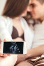 Young couple in love showing an ultrasound picture of their baby Royalty Free Stock Photo