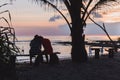 Silhouettes of loving couple embracing each other at sunset by the sea. Royalty Free Stock Photo