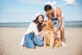 Young couple in love sitting on the beach with dog Royalty Free Stock Photo