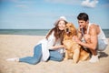 Young couple in love sitting on the beach with dog Royalty Free Stock Photo