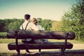 Young couple in love sitting on a bench in park. Vintage Royalty Free Stock Photo