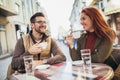 Young couple in love sitting at the cafe table outdoors, drinking coffee Royalty Free Stock Photo