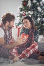 A young couple in love sitting on the floor enjoying Xmas presents. Christmas, relationship, love, together Royalty Free Stock Photo