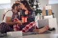 A young couple in love sitting on the floor with Xmas presents. Christmas, relationship, love, together Royalty Free Stock Photo