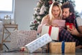 A young couple in love sitting at home looking forward Xmas presents. Christmas, relationship, love, together Royalty Free Stock Photo