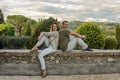 Young couple in love sitting on a stone fence overlooking the Italian mountains Royalty Free Stock Photo