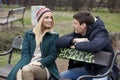 Young couple in love sitting together on the bench in the park Royalty Free Stock Photo