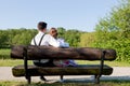 Young couple in love sitting together on a bench in park Royalty Free Stock Photo