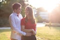 Young couple in love standing close to each other, enjoying the summer sunshine in the park Royalty Free Stock Photo