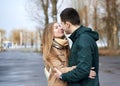 Young couple in love, standing, looking at each other, hugging, wearing casual clothes and jeans, on the rainy spring day. Royalty Free Stock Photo