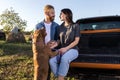 Young couple in love and their faithful canine American bully dog companion sitting on the back of a pickup truck