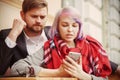 Young couple in love while traveling monitoring their stock prices remotely with smart phone Royalty Free Stock Photo