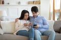 Young couple in love using gadgets together sharing interesting information