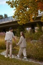 Young couple in love walking in the autumn park holding hands. Couple in Love Strolling Hand in Hand through the Park Royalty Free Stock Photo