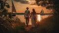 A young couple in love walking by the the beach at sunset. Holding hands with sail boats in the background.