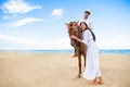 Young couple in love walking with the horse at sea beach on blue sky . honeymoon tropical sea summer vacation. bride groom on the