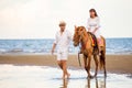 Young couple in love walking with the horse at sea beach on blue sky . honeymoon tropical sea summer vacation. bride groom on the Royalty Free Stock Photo