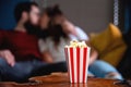 A young couple in love watching television at night romantic date night lying on the couch eating popcorn Royalty Free Stock Photo