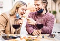 Young couple in love wearing open face masks having fun at wine bar outdoor - Happy traveler friends enjoying lunch together Royalty Free Stock Photo