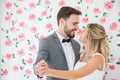 young couple in love Wedding Bride and groom dancing together and looking at each other on roses backdrop . Newlyweds. portrait Royalty Free Stock Photo