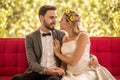 young couple in love Wedding Bride and groom sitting on red sofa looking at each other and embracing together . Newlyweds . Royalty Free Stock Photo