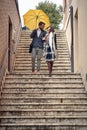 A young couple in love which is descending the stairs in the city during a rainy day. Walk, rain, city, relationship Royalty Free Stock Photo
