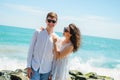 A young couple of lovers, a guy and a girl on the ocean, in white clothes on the stones.