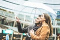 Young couple of lovers having fun discovering city urban center under the rain - Love, fall, travel, winter weather, casual Royalty Free Stock Photo