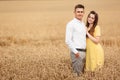 A young couple of lovers woman and man hugging in nature, in a yellow wheat field. The concept of love, good relationships,